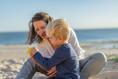 A mother and son playing together on the beach
